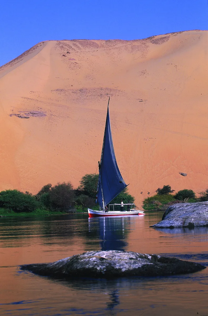 Felouque naviguant au pied d’une dune près d’Assouan