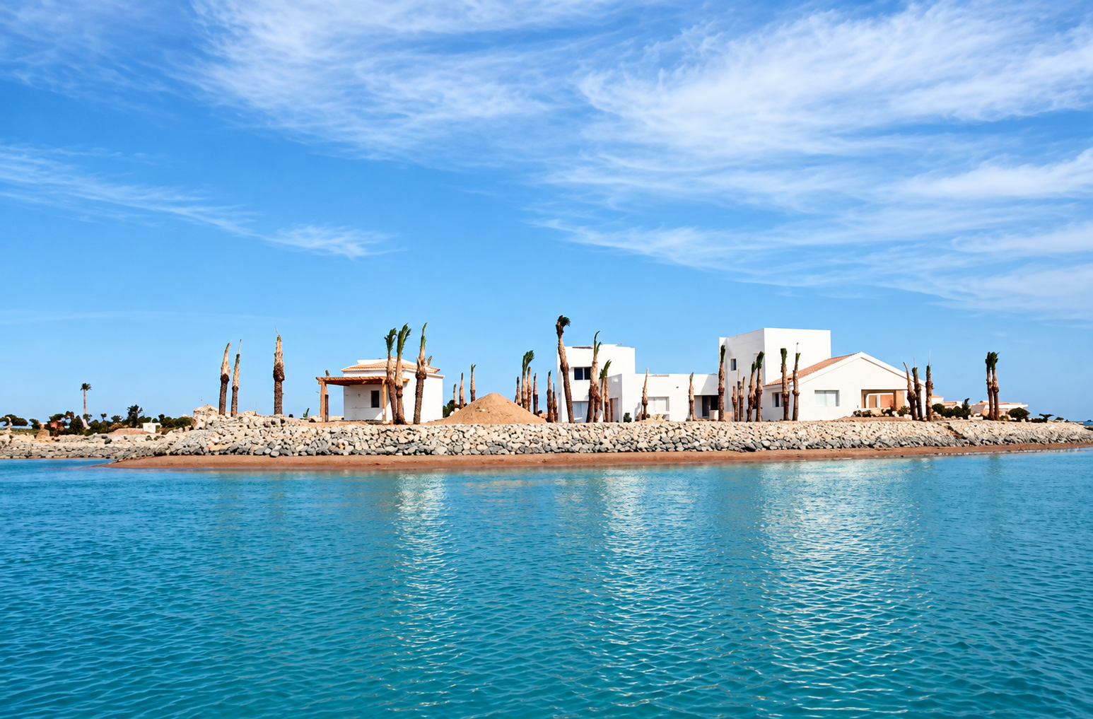 Recréation du bord de l’eau à El Gouna : bâtiments clairs, palmiers, eau turquoise et ciel bleu