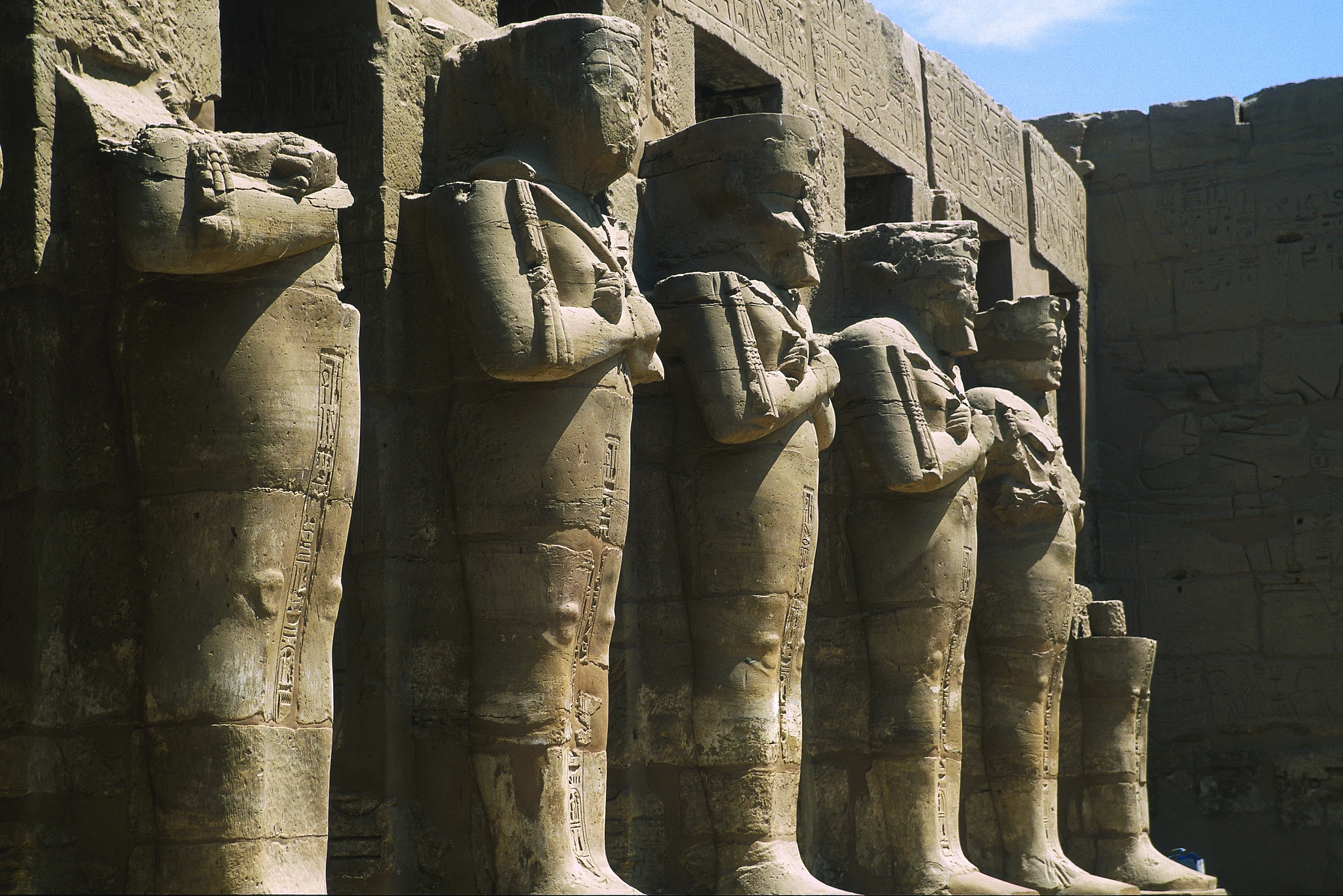À Karnak, les statues royales se détachent devant les piliers du portique de Ramsès III.