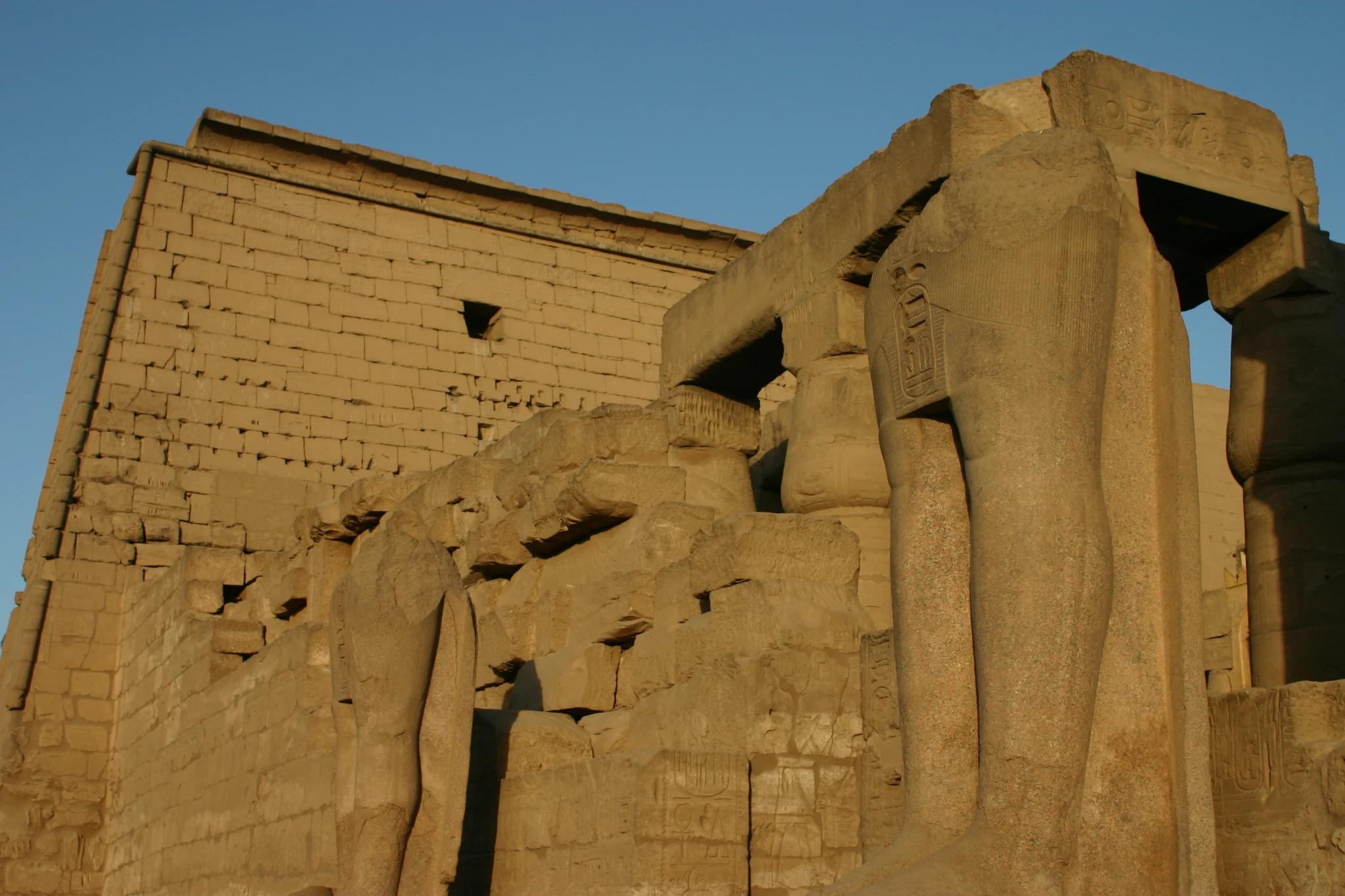 Les reliefs et les statues devant le pylône de Ramsès II à Louxor.